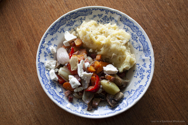 A photo of a plate of food, featuring roasted veg, mashed potatoes, and crumbly feta cheese.